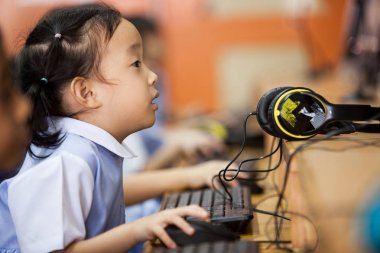 Genç okul çocukları bir bilgisayar kullanmayı öğrenmeye başlamak.
