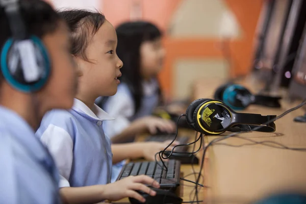 Young school kids start learning how to use a computer. — Stock Photo, Image