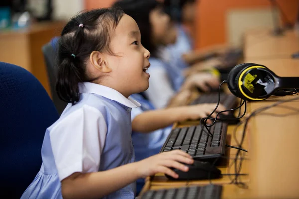 Young school kids start learning how to use a computer. — Stock Photo, Image