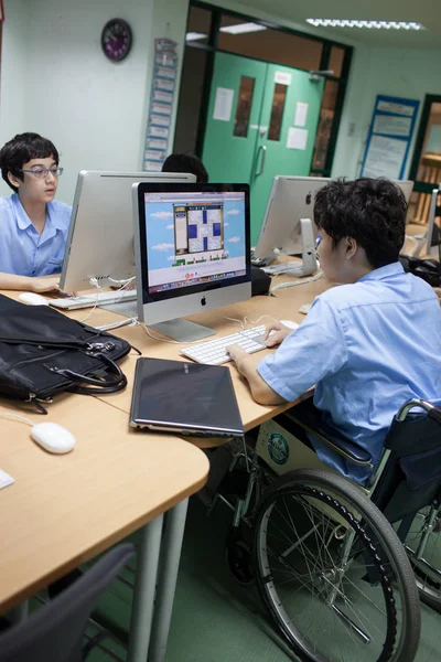 In a college in Bangkok, a disabled student in computer class. — Stock Photo, Image