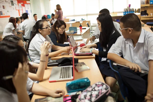 Un grupo de estudiantes en un aula trabajando juntos en un ejercicio — Foto de Stock