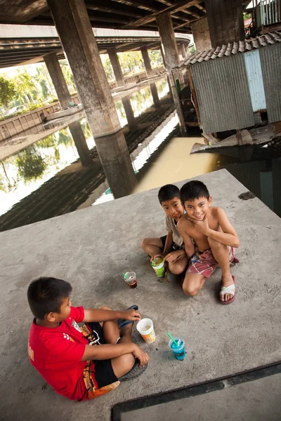 Un gruppo di giovani ragazzi si divertono insieme nella baraccopoli di Klong Toey a Bangkok — Foto Stock