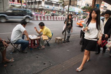 iki adam gündüz Bangkok gürültülü bir sokakta oturan Şişe kapakları ile dama oynarken zevk.