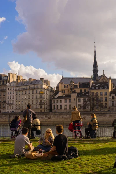 Os turistas bebem e fazem piquenique nas margens do rio Sena, em Paris, durante um dia ensolarado de primavera. — Fotografia de Stock