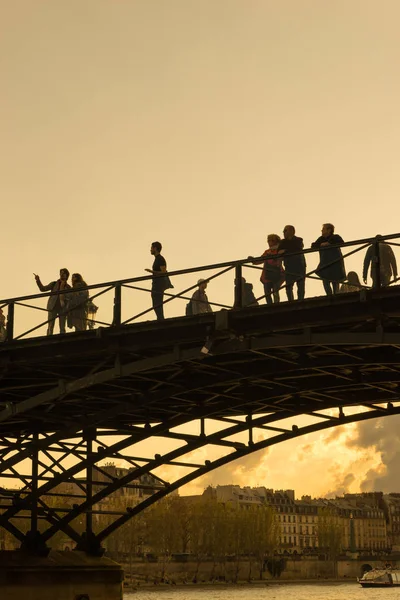 Os turistas apreciam o calor da primavera, em uma ponte do rio Sena em Paris . — Fotografia de Stock