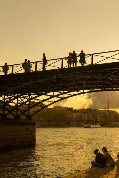 Les touristes profitent de la chaleur du printemps, sur un pont de la Seine à Paris . — Photo