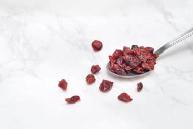 Bir kaşık beyaz mermer zemin üzerine Cranberries kurutulmuş