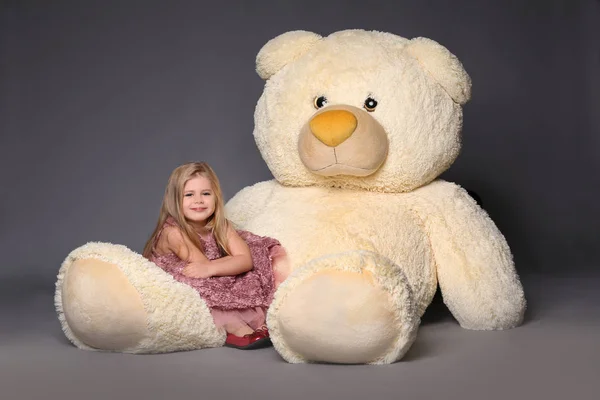 Baby sitting on the large teddy bear — Stock Photo, Image