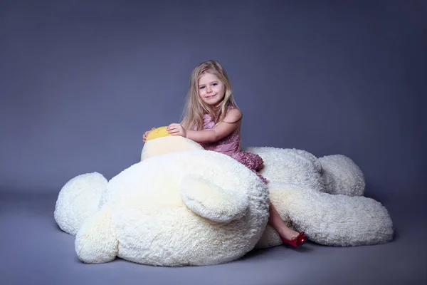 Enfant assis sur un gros ours en peluche — Photo