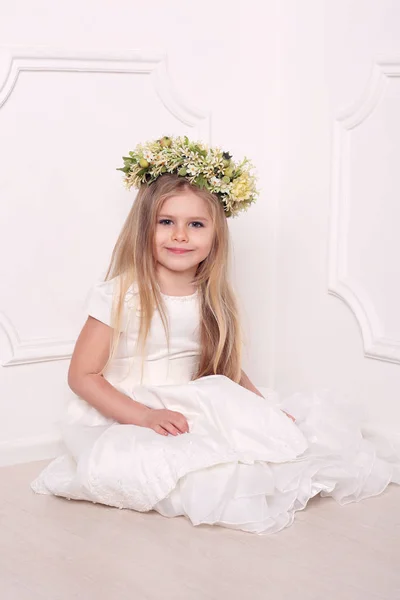 Kid i klänning med blomman krans. Vit bakgrund — Stockfoto