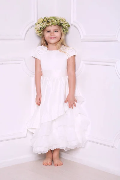 Klein meisje in de jurk met de kroon van het hoofd. Witte achtergrond — Stockfoto