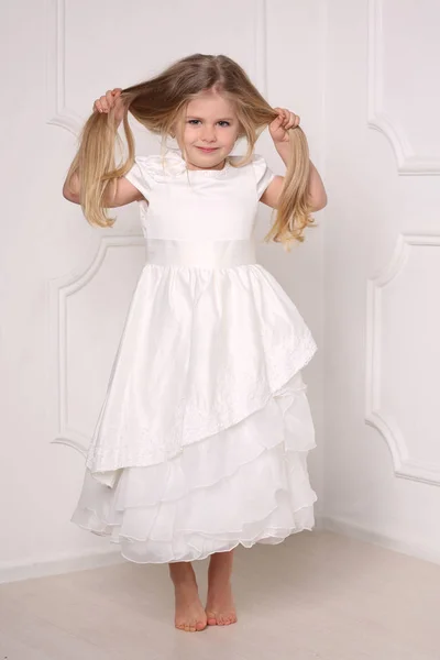 Kleine prinses in jurk houden van haar haren. Witte achtergrond — Stockfoto