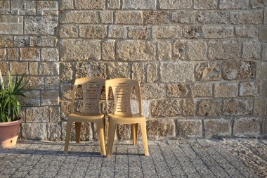 Taş duvar arka plan üzerinde plaj sandalyeleri