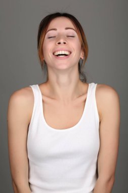 Tanktop kapalı gözlü kız. Yakın çekim. Gri arka planı