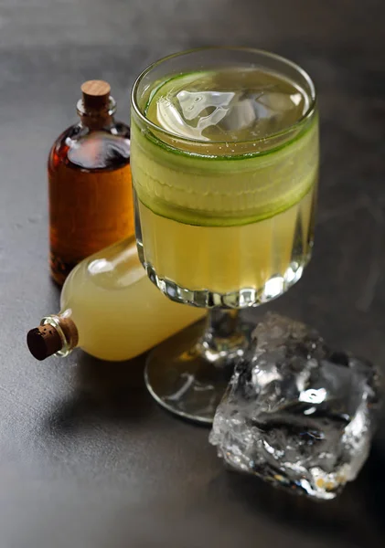 Cocktail with cucumber and two bottles — Stock Photo, Image