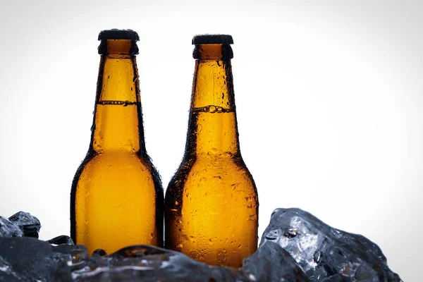 Två flaskor av ale i is. Närbild. Vit bakgrund — Stockfoto