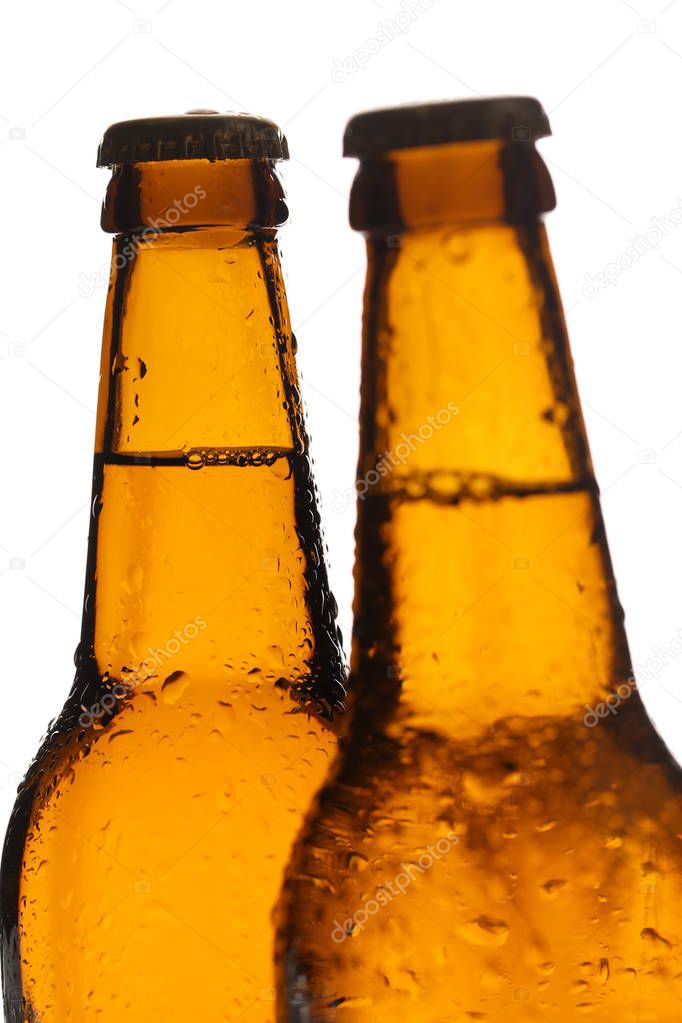 Two bottles of ale with drops. Close up. White background