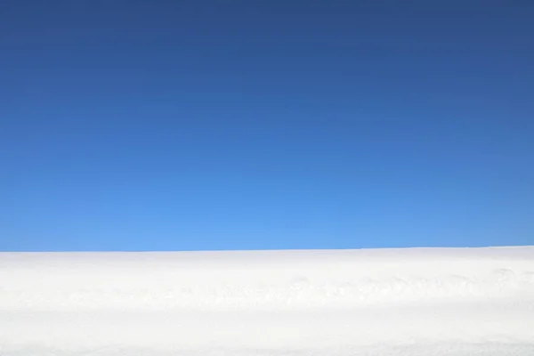 Śnieg na błękitnym tle nieba — Zdjęcie stockowe