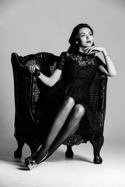 Modell auf dem Sessel in schwarz und weiß. Fotoretuschee — Stockfoto
