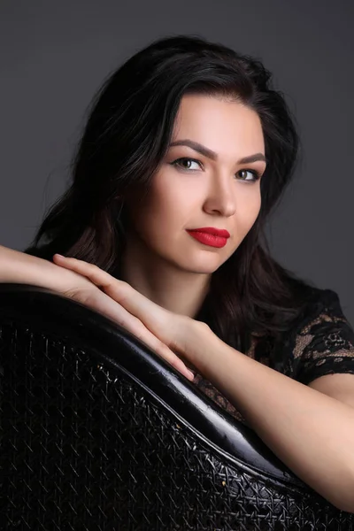 Model sitting on the black chair. Close up. Photographie retouchee — Stock Photo, Image