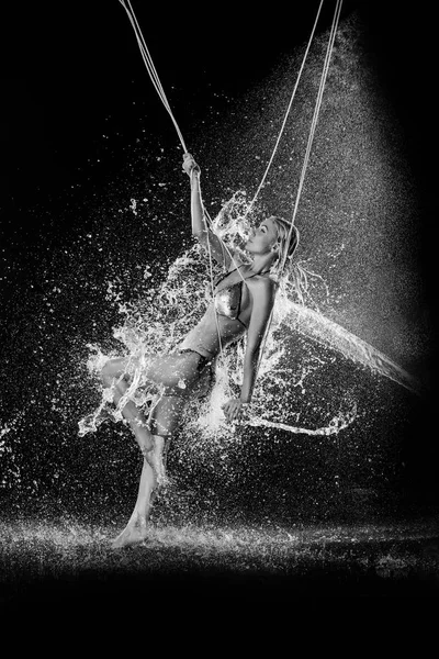 Frau im Wasser spritzt Schaukeln auf dem Seil. Schwarz-Weiß. Fotoretuschee — Stockfoto