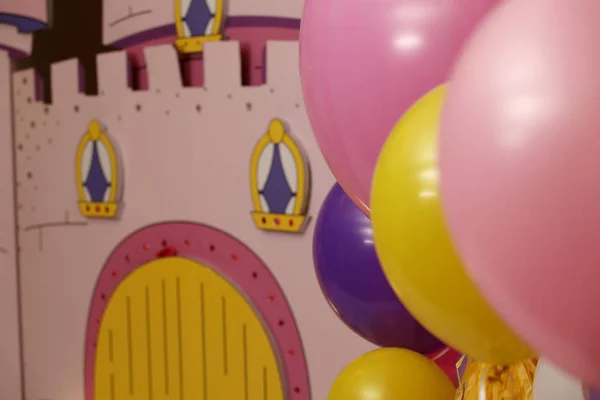 Żółty i różowy balony na tle domu zabawka. Selektywny fokus — Zdjęcie stockowe