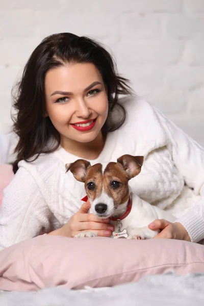 Menina deitada na cama com o seu pequeno cão. Retoques fotográficos — Fotografia de Stock