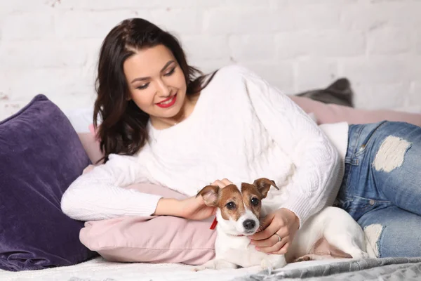 Menina deitada na cama com o filhote. Retoques fotográficos — Fotografia de Stock