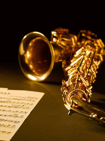 Gouden saxofoon op donkere achtergrond. — Stockfoto
