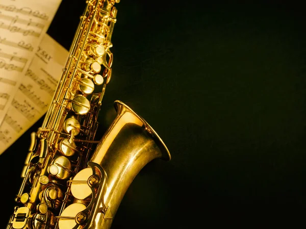 Gouden saxofoon op donkere achtergrond. — Stockfoto