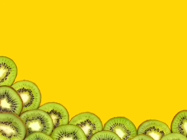 Pedaços de kiwi em um fundo amarelo . — Fotografia de Stock