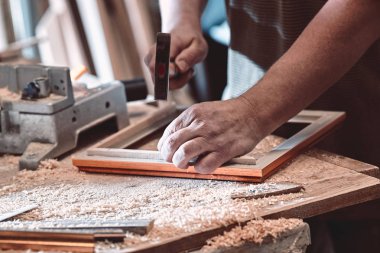 Resimler için çerçeveler marangoz atölyesinde yapar.