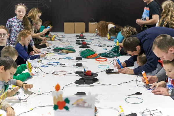 Un grupo de niños aprende a dibujar una pluma 3D . — Foto de Stock