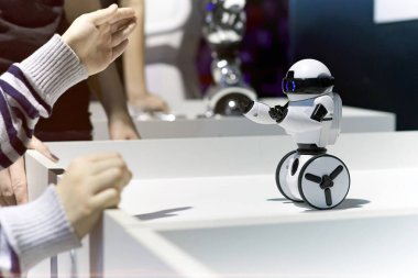 Çocuk küçük bir robot ile oynuyor.