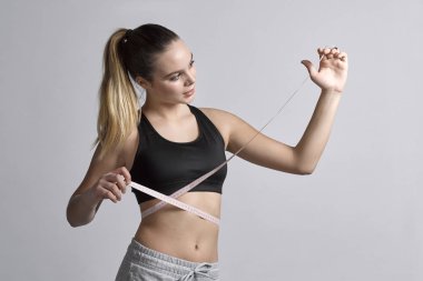 Genç fitness kız üzerinde esnek cetvelle beline ölçer bir