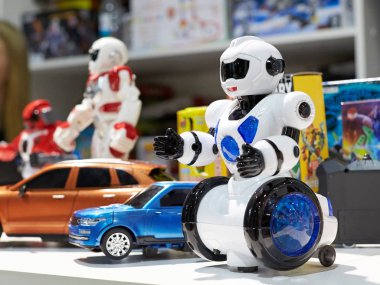 Beyaz oyuncak robot ve depodaki diğer robotlar.