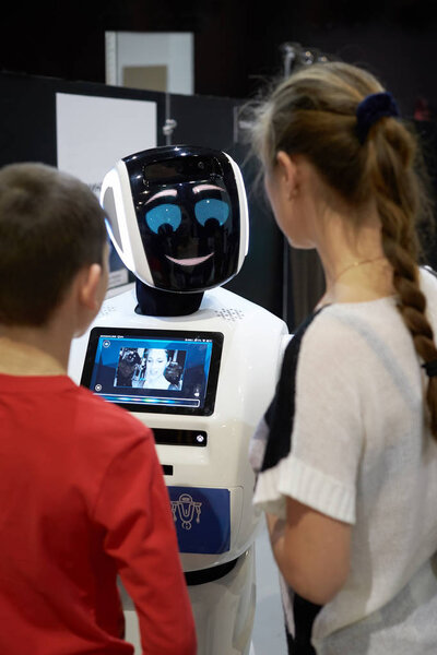 Дети разговаривают, играют с роботом-андроидом
.