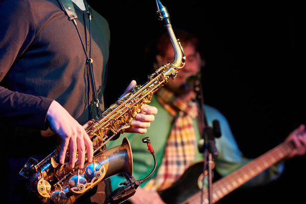 Closeup of a saxophonist and guitarist playing saxophone and gui