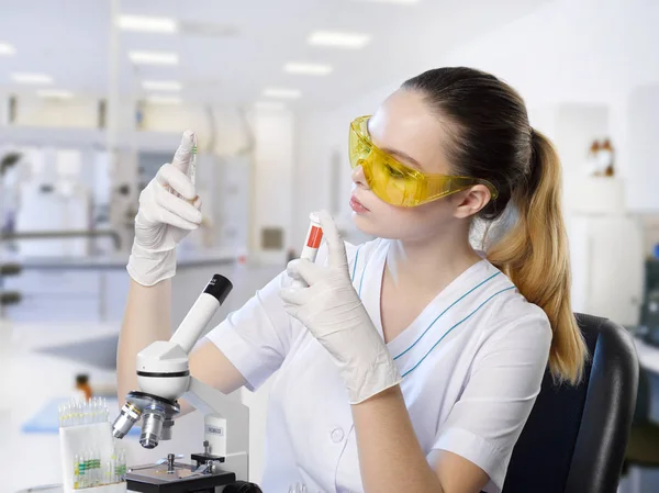 Jovem menina bonita assistente de laboratório médico em amarelo protetor g — Fotografia de Stock