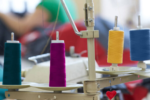 Closeup of coils with colored threads on sewing machine overlock
