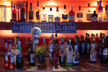 Sayaç alkol şişeleri ve güzel bir kırmızı arka ışık ile Bar, 