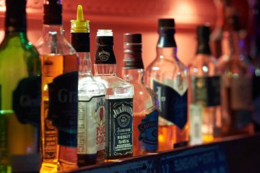 Sayaç alkol şişeleri ve güzel bir kırmızı arka ışık ile Bar.