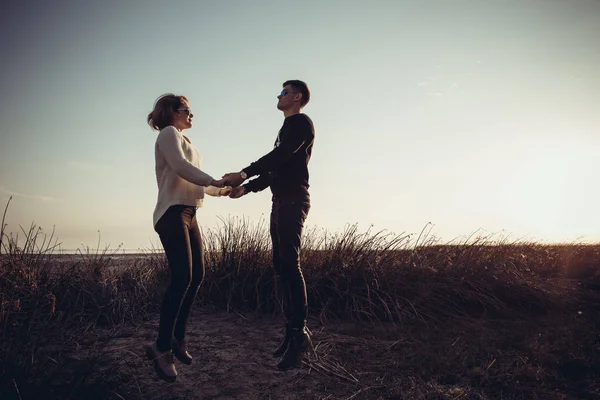 Una pareja amorosa de adolescentes saltando tomados de la mano . — Foto de Stock