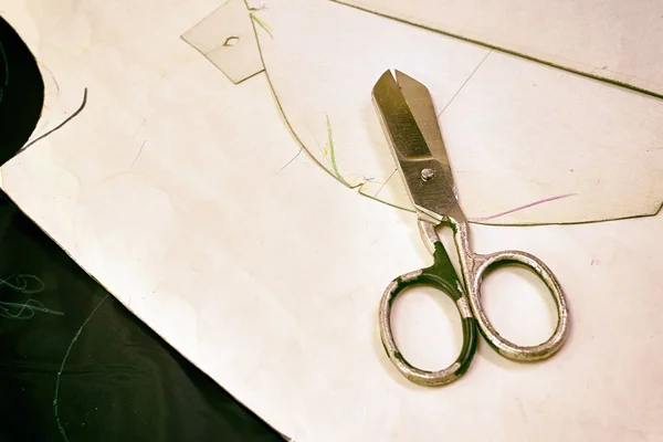 Old tailor's scissors on the cutter's desk, along with paper ste — Stock Photo, Image