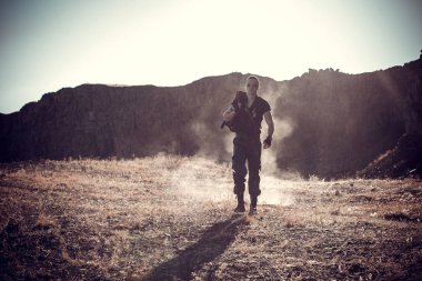 Yalnız bir savaşçı bir takım elbise kıyameti alanına yürüyor bir