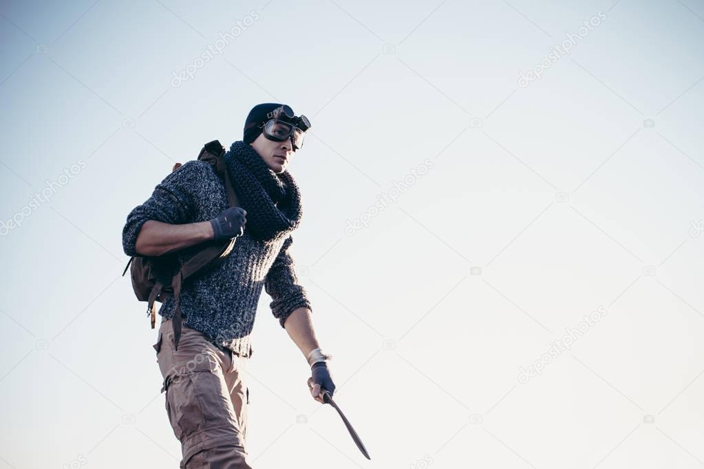 A lonely warrior walks along the road in a suit and goggles surv