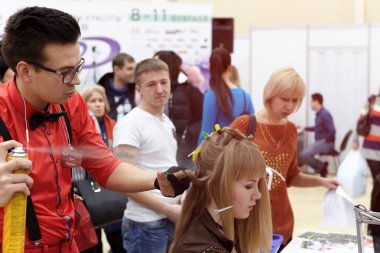 Bir adam bir saç modeli yeni eğilimler vitrin bir kız için yapıyor 