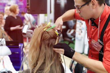 Bir adam bir saç modeli yeni eğilimler vitrin bir kız için yapıyor 