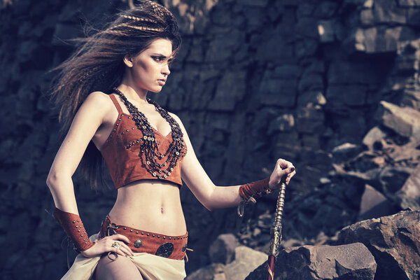 Beautiful girl in the clothes of a Viking or Amazon, with a swor