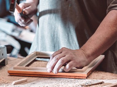 Marangoz closeup çerçeve bir çekiç kullanarak resimleri için toplar.